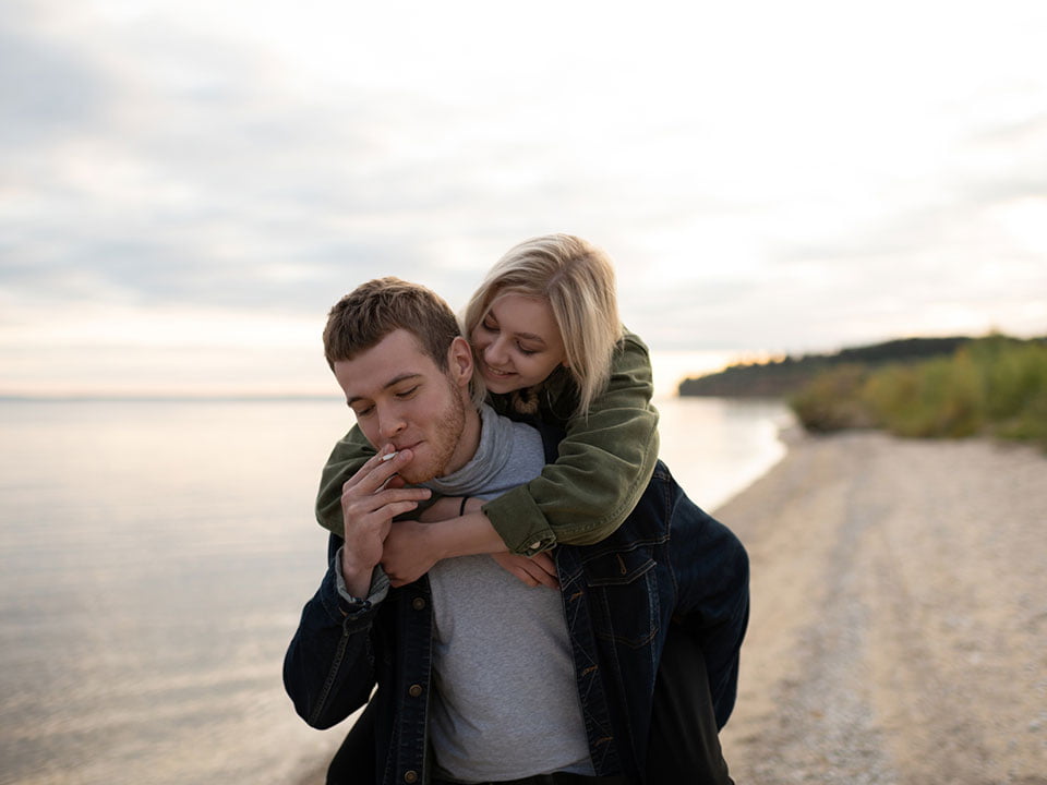 couple walking on beach smoking