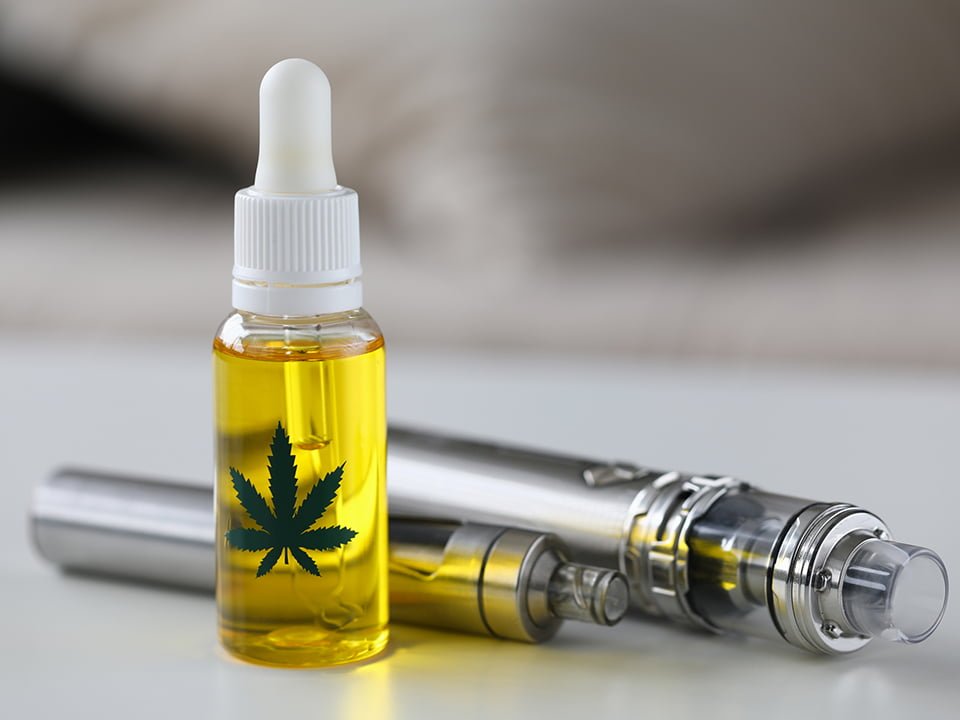 Organic extra virgin cannabinoid oil with vipe pen system against home background.